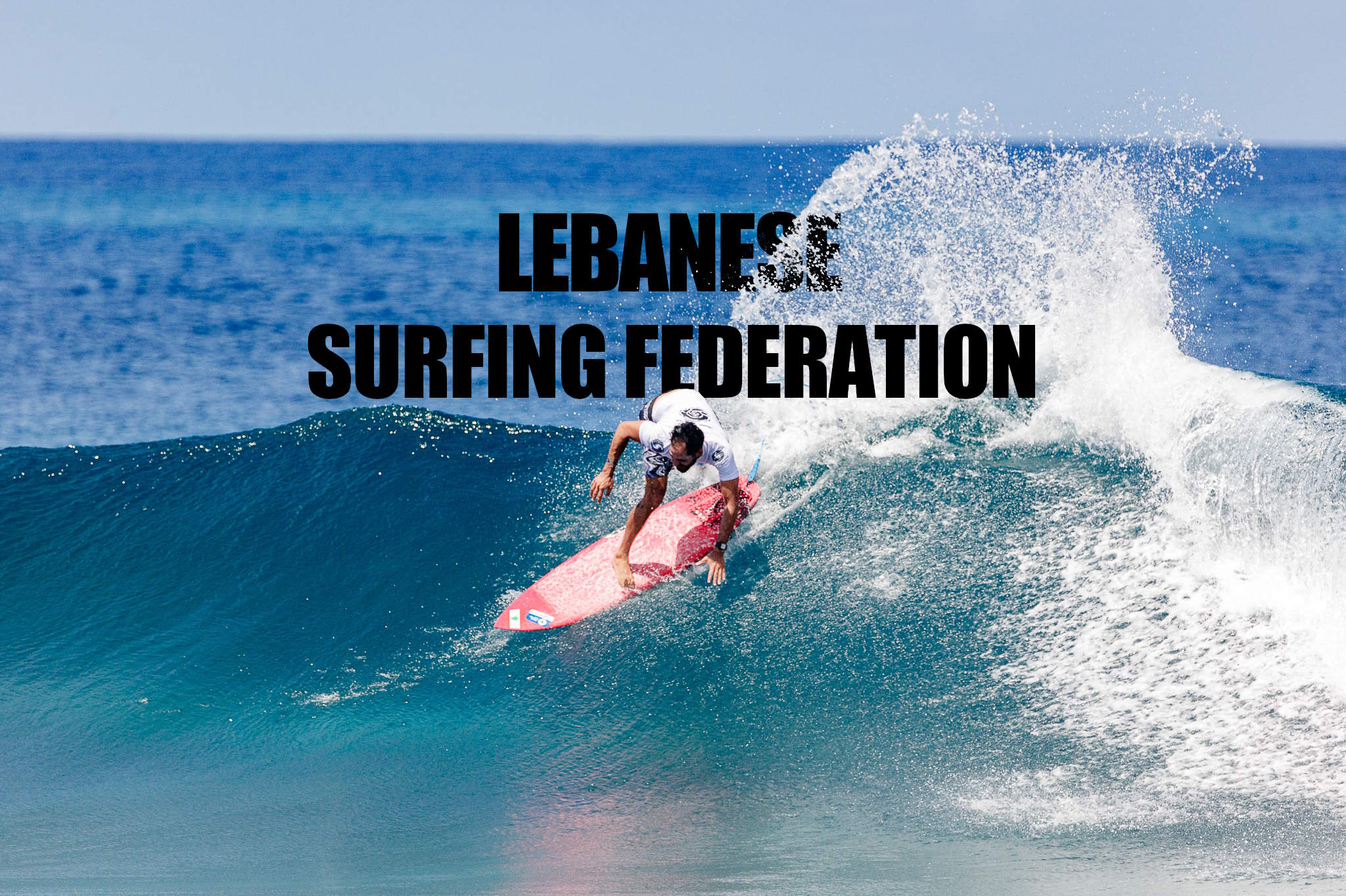 Surfer doing top turn spraying water on the text Lebanese Surfing Federation